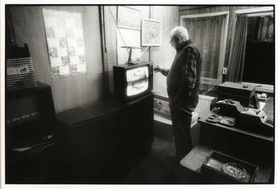107966 Afbeelding van een man bij een televisietoestel met testbeeld in een ruimte van het Leger des Heils te Utrecht.